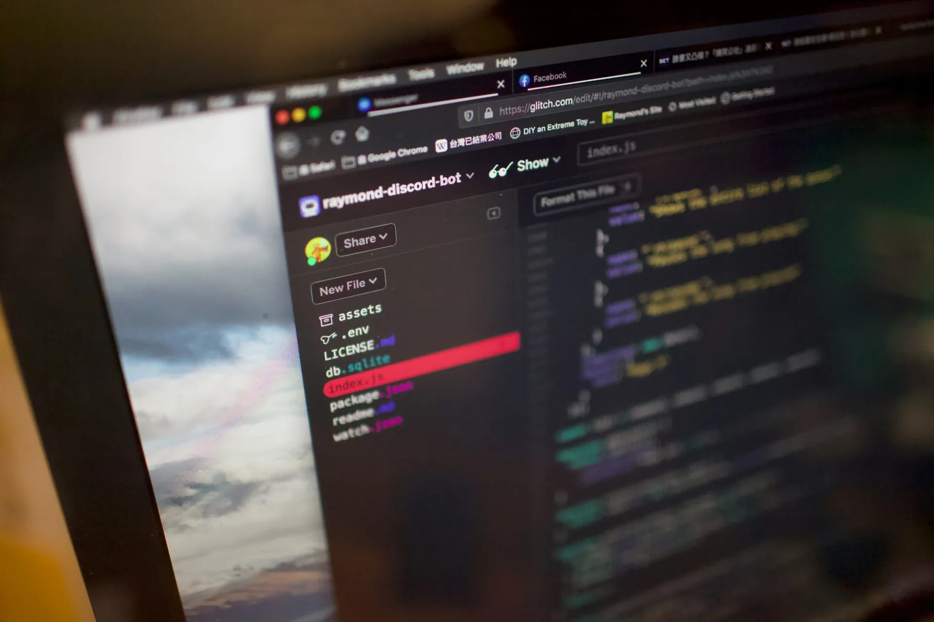 Écran d'ordinateur affichant un éditeur de code avec un projet nommé 'raymond-discord-bot' ouvert, montrant la structure de fichiers à gauche et du code JavaScript à droite.