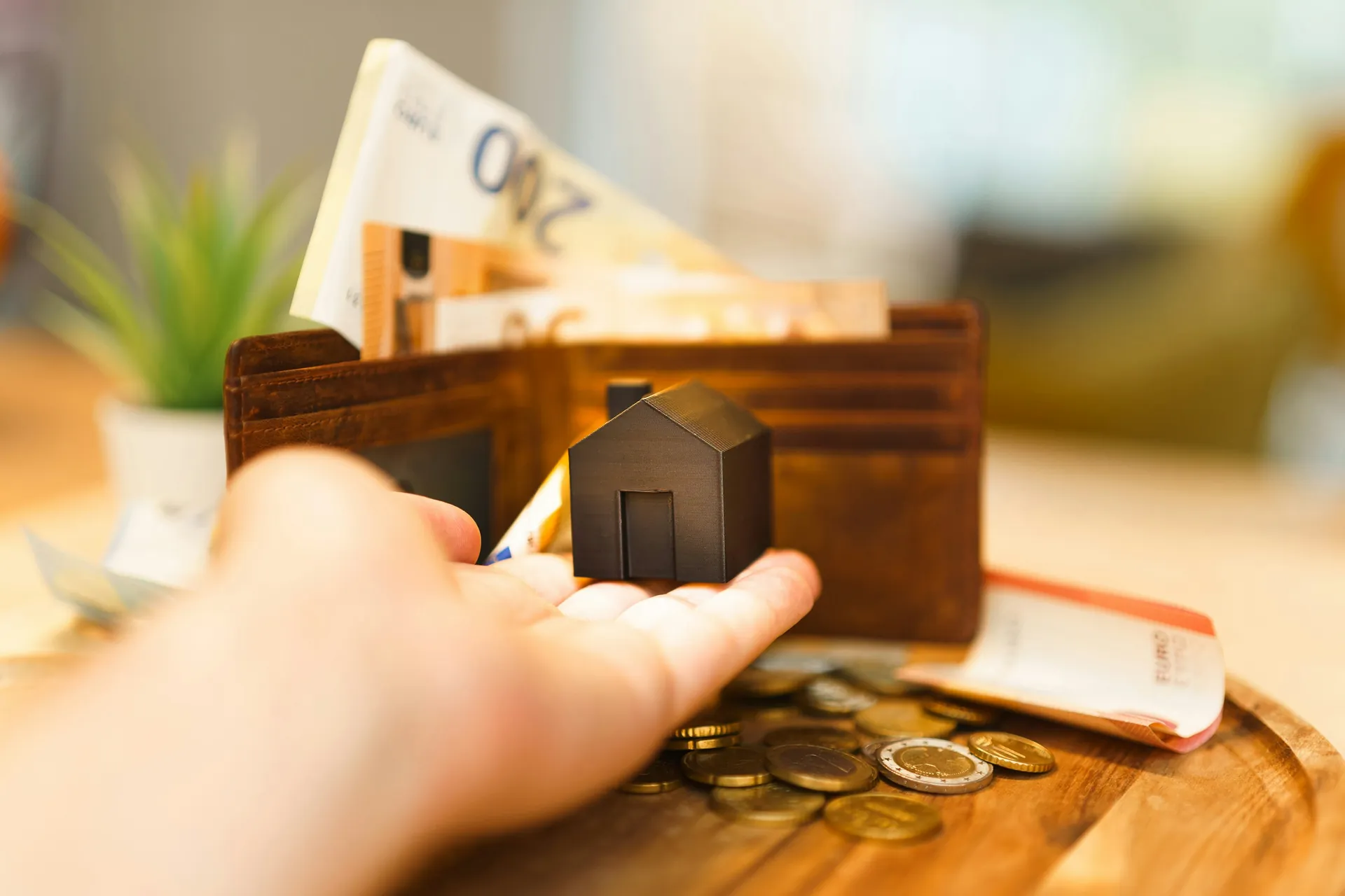 Petite maison noir, portefeuille et billets