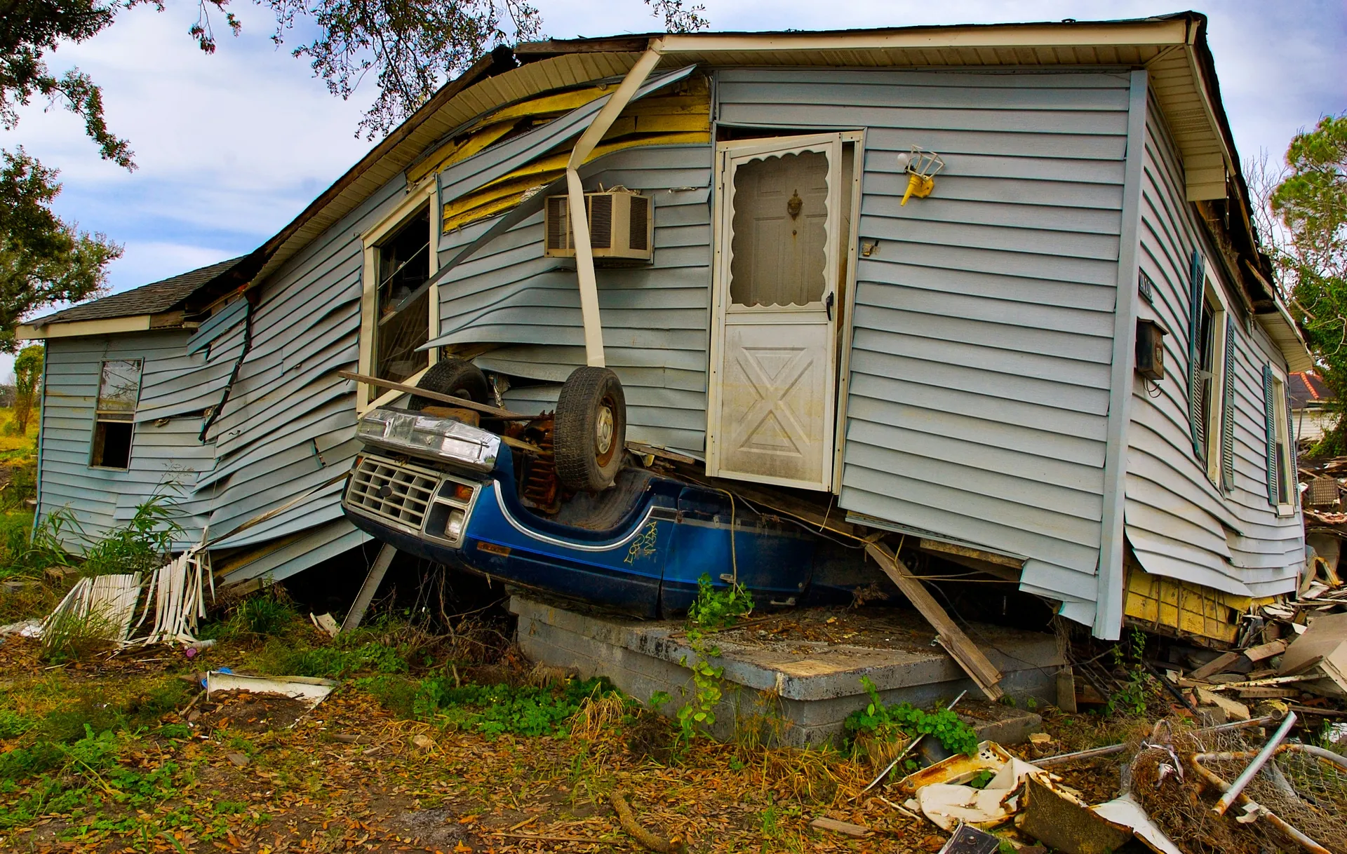 Maison en mauvais état, voiture en dessous