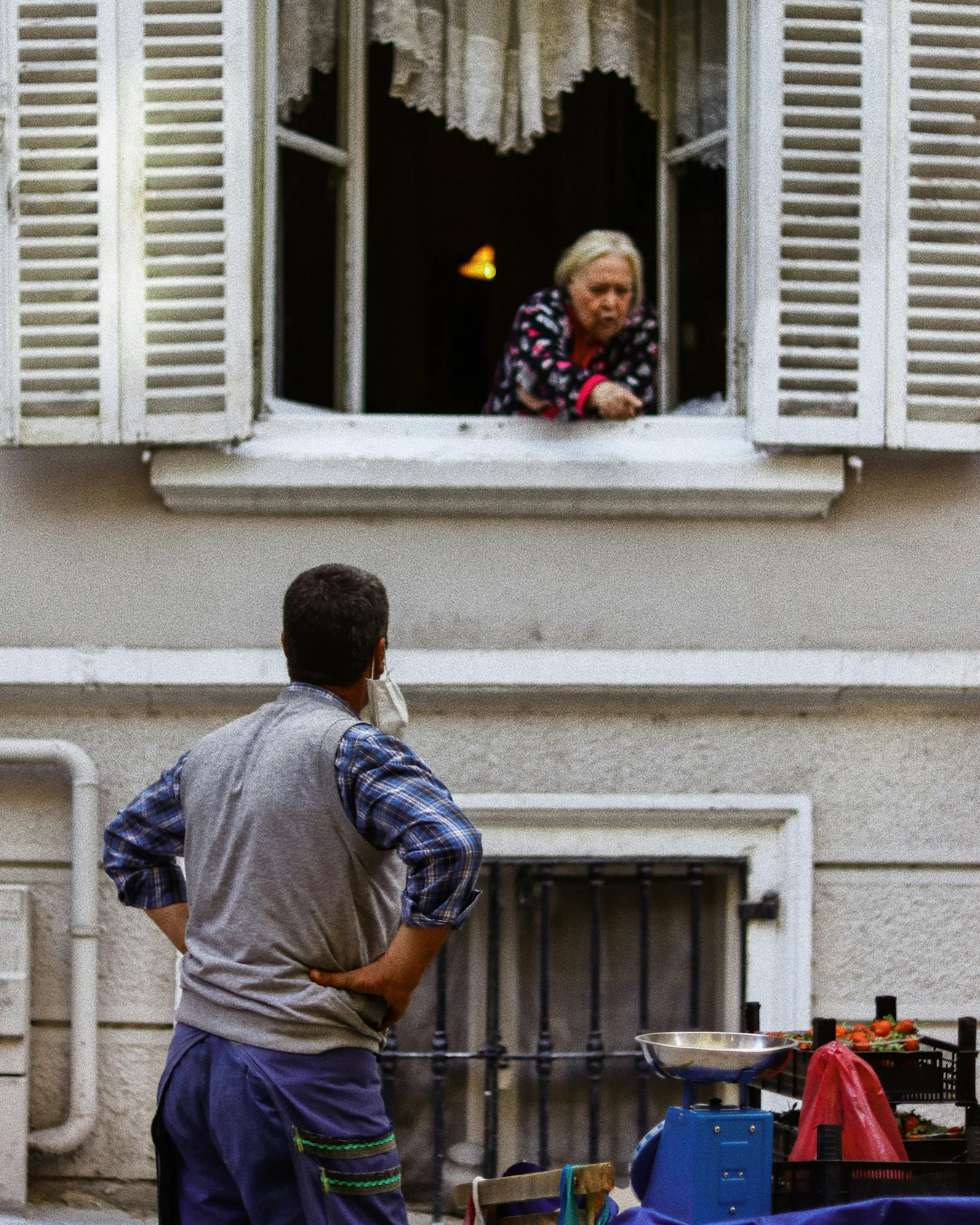 Vieille dame qui parle à un monsieur par sa fenêtre 